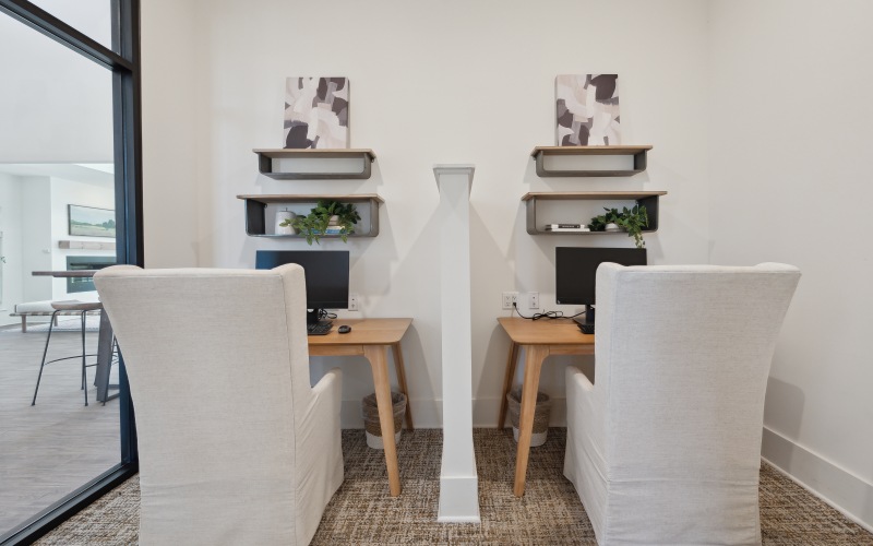 two small desks with a privacy wall in between them