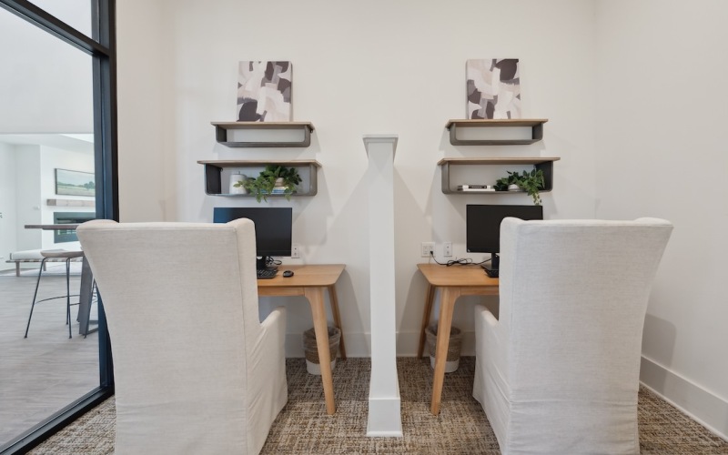 two small desks with a privacy wall in between them