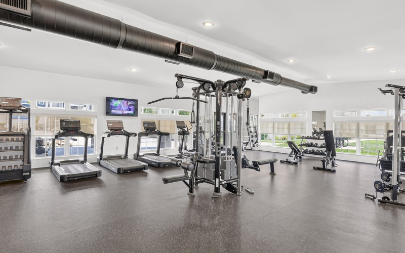 fitness center with treadmill aligned a wall